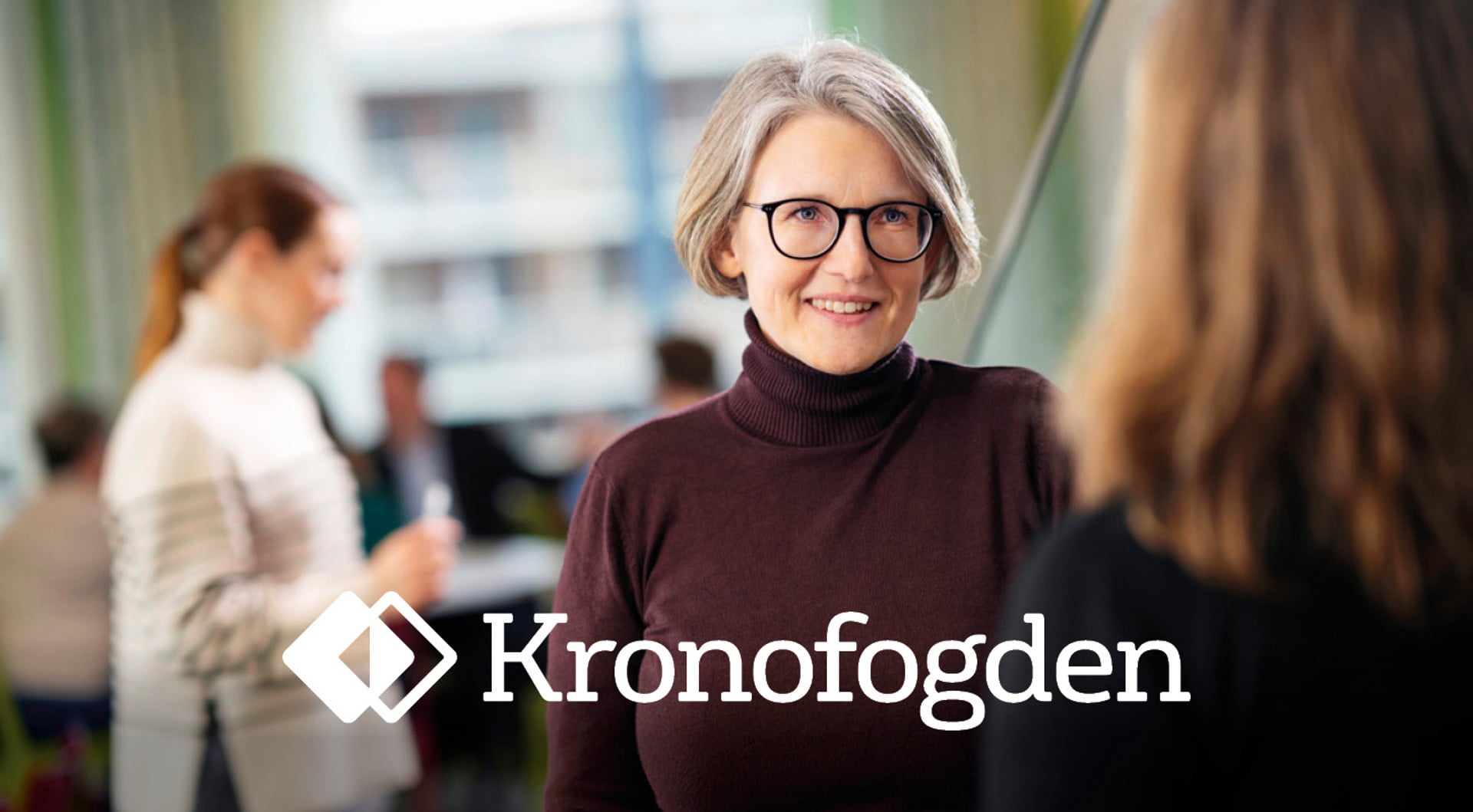 Kvinna med glasögon i förgrunden. Kronofogdens logotyp.