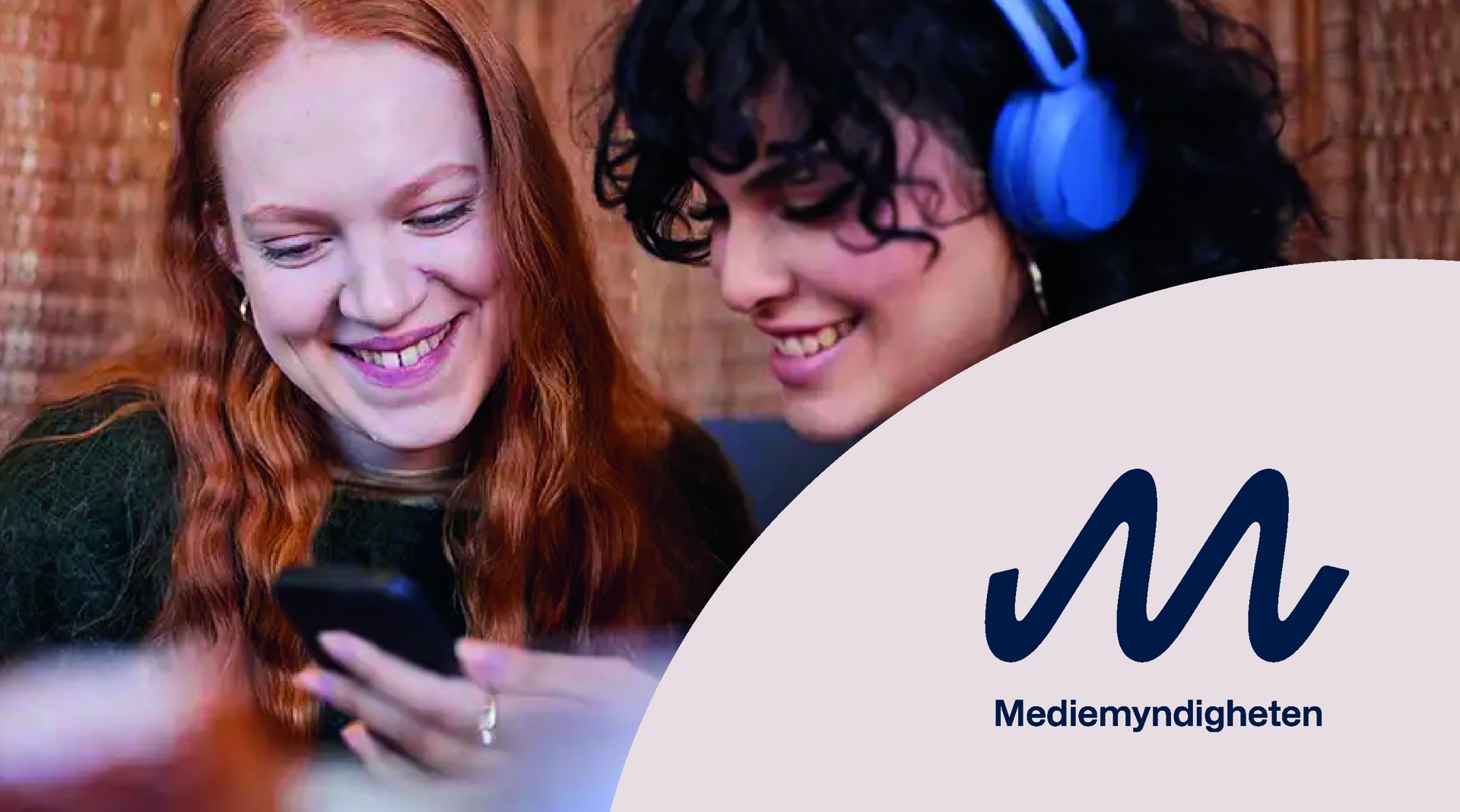 Två leende kvinnor och en platta med Mediemyndighetens logotyp