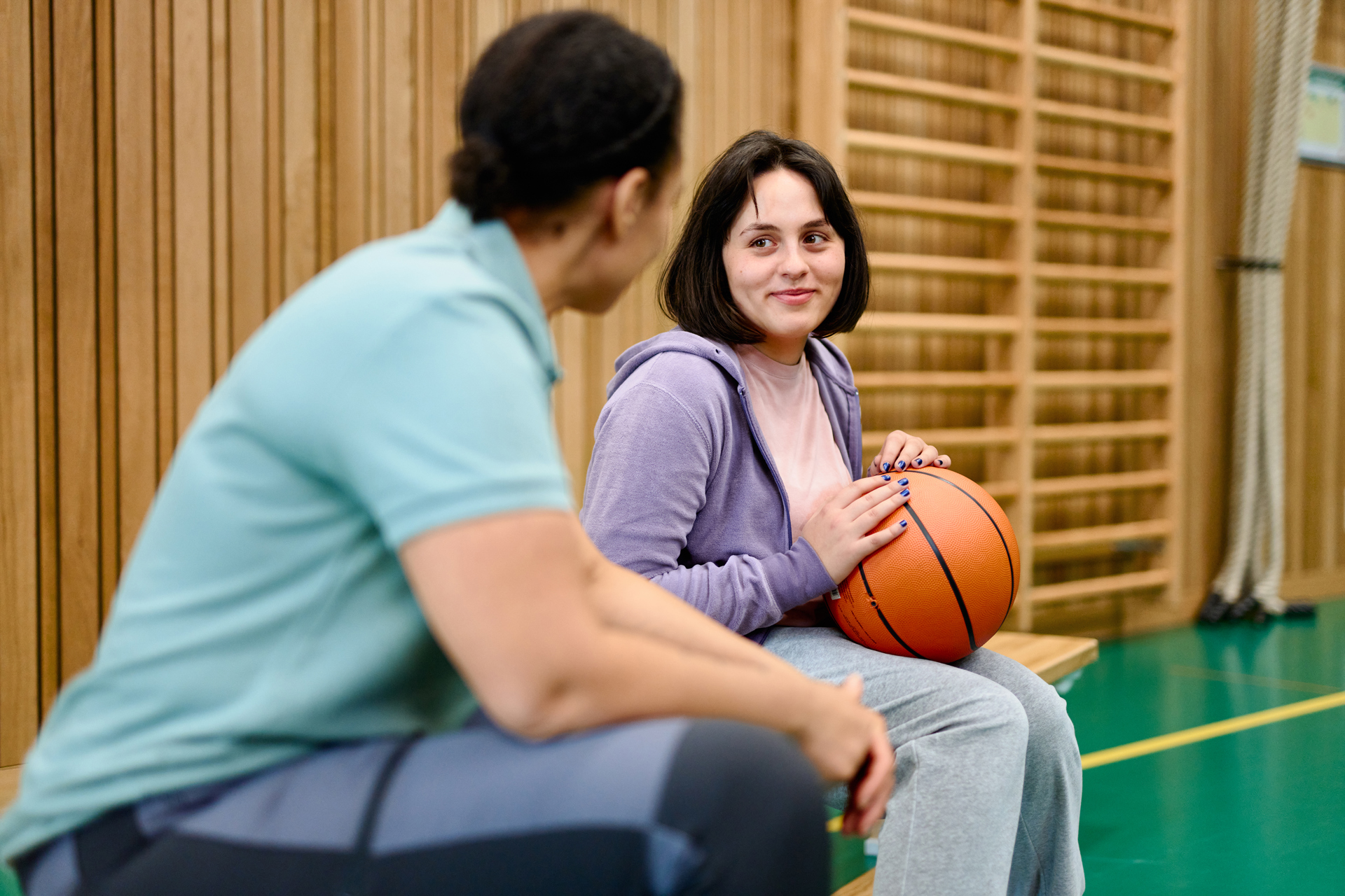 Lärare och elev med basketboll på idrottslektion.