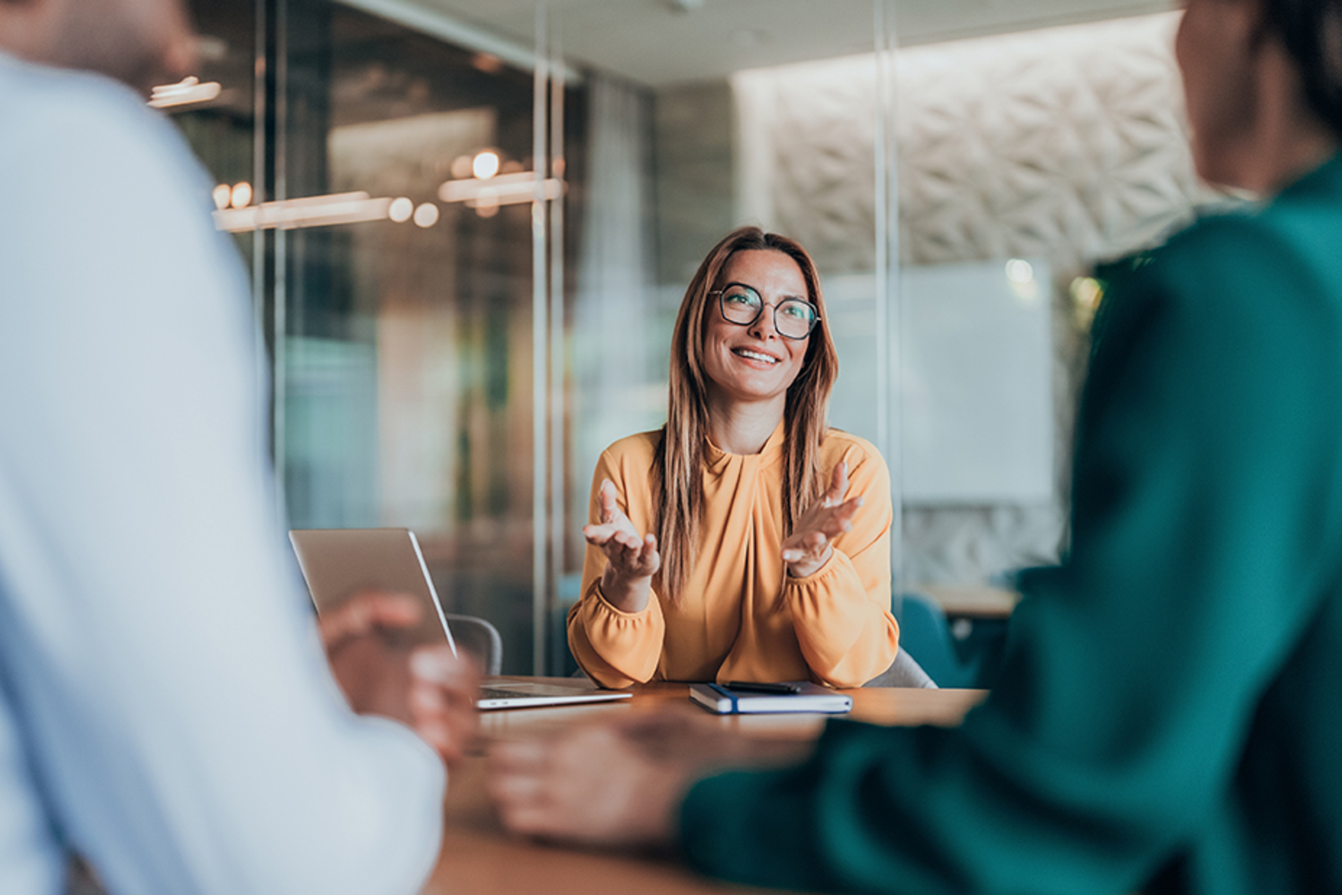 Leende kvinnlig jurist i samtal med kollegor på kontor